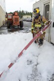 Firefighters assigned to the 673d Civil Engineer Squadron train during the foam test at Hangar 18 on Joint Base Elmendorf-Richardson, Alaska, Aug. 31, 2017. The firefighters were a part of the foam test to practice and train for rescue operations. (U.S. Air Force photo by Airman 1st Class Caitlin Russell)