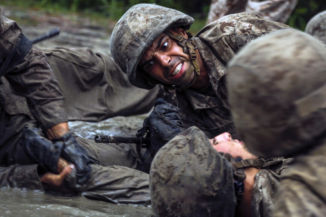 A group of Marines train in the mud.