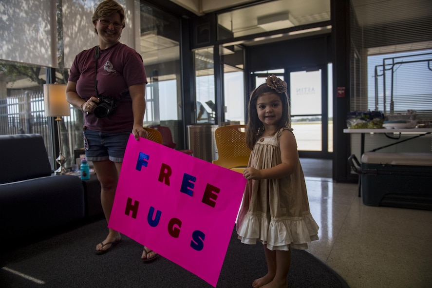 Kaitlyn O'Rear, 3, and her mom show off their "free hugs" sign, Sept. 2, 2017, at Easterwood Airport in College Station, Texas.