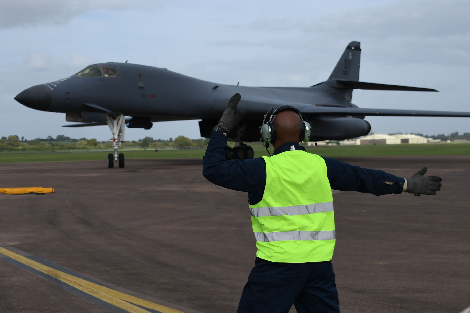 U.S. Air Force Tech. Sgt. Terance Thomas, 489th Bomb Group flight chief, marshals a B-1B Lancer after it landed at Royal Air Force Fairford, United Kingdom, Sept. 6, 2017.