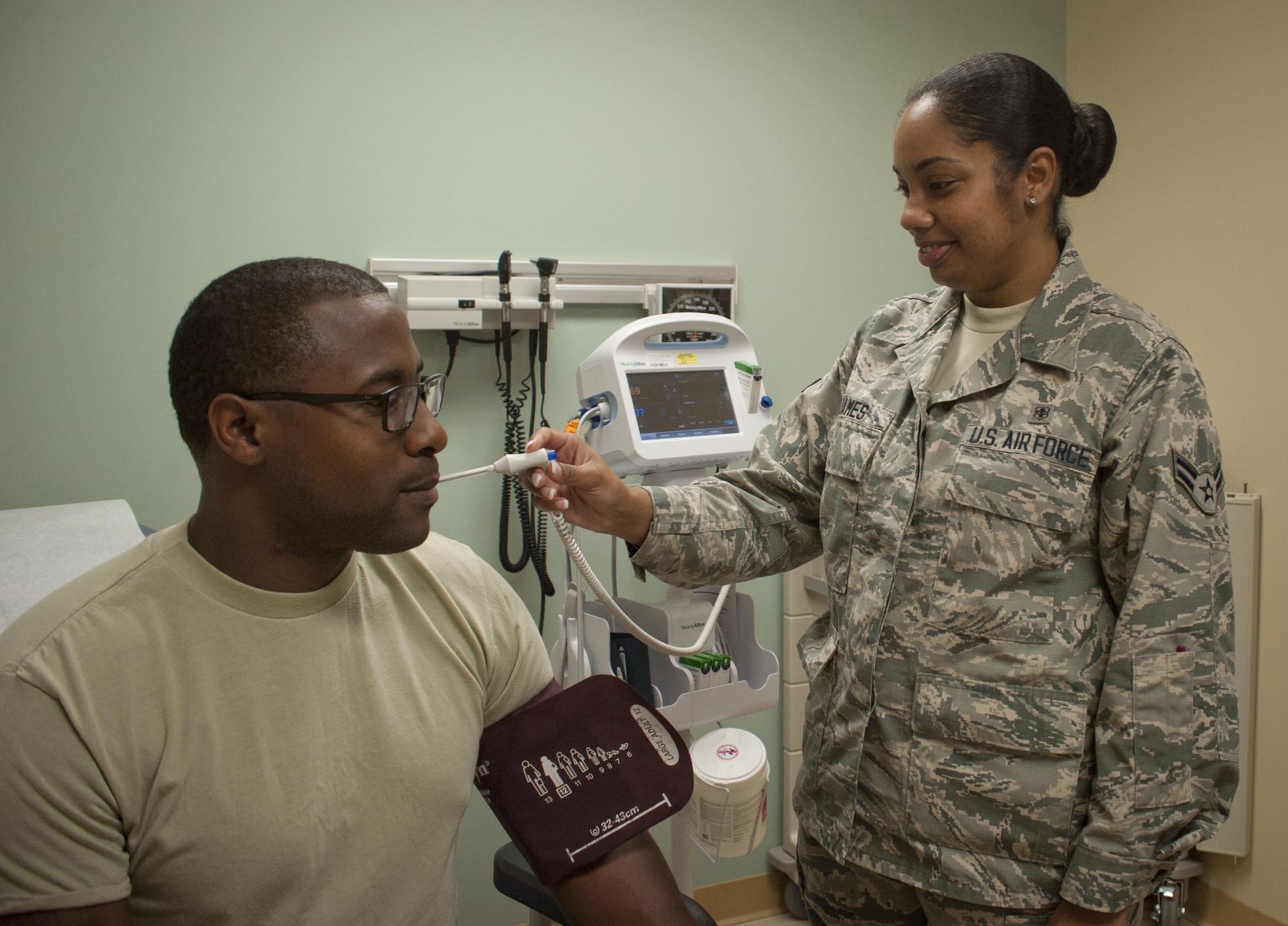 U.S. Air Force Airman 1st Class Alicia James, right, an aerospace medical service technician assigned to the 6th Medical Support Operations Squadron, takes a patient’s temperature and blood pressure in the 6th Medical Group Clinic at MacDill Air Force Base, Fla., Sept. 7, 2017. The family health clinic sees approximately 180 patients daily and averages 39,000 appointments each year. (U.S. Air Force photo by Senior Airman Mariette Adams)