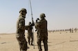 Three soldiers hoisting an antenna.