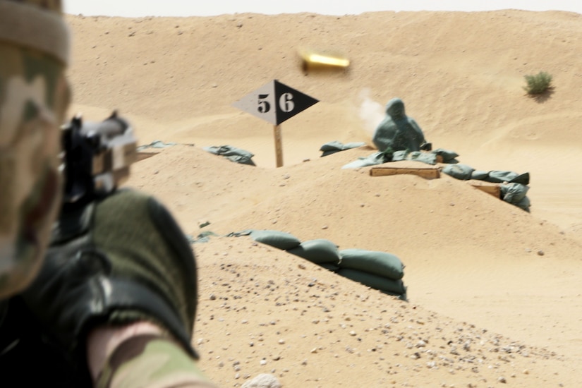 Over the shoulder shot of a soldier aiming at a target on a pistol range
