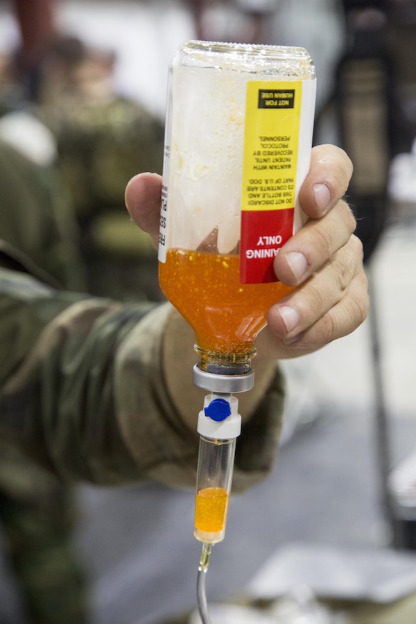 Critical skills operators with U.S. Marine Corps Forces, Special Operations Command simulate administering freeze-dried plasma to a role-playing casualty during a Raven pre-deployment exercise at Camp Shelby Joint Force Training Center, Miss., May 1, 2017.  After FDP returns from a deployment it’s put into quarantine and used during training exercises by CSOs and the Special Amphibious Reconnaissance Corpsmen. (U.S. Marine Corps photo by Sgt. Salvador R. Moreno)