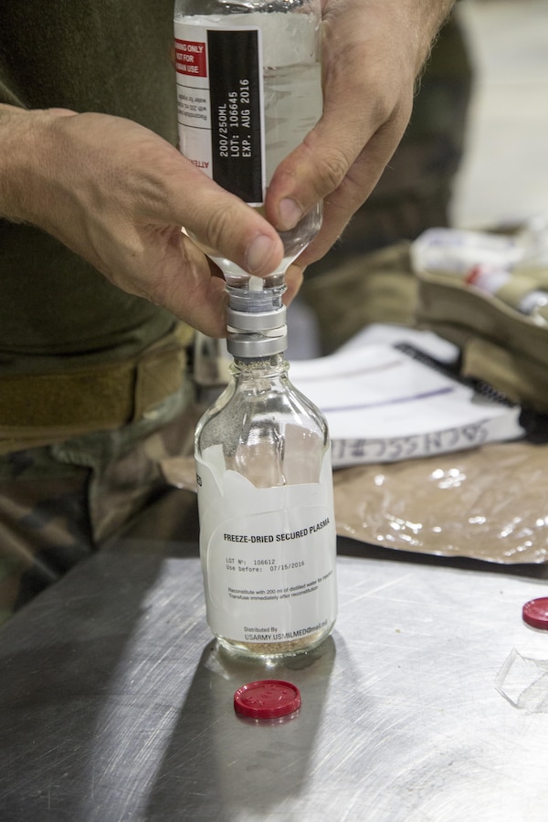 Critical skills operators with U.S. Marine Corps Forces, Special Operations Command, reconstitute freeze-dried plasma during a Raven pre-deployment exercise at Camp Shelby Joint Force Training Center, Miss., May 1, 2017.  CSOs go through a condensed version of FDP training to familiarize themselves with the product for use in the field. (U.S. Marine Corps photo by Sgt. Salvador R. Moreno)