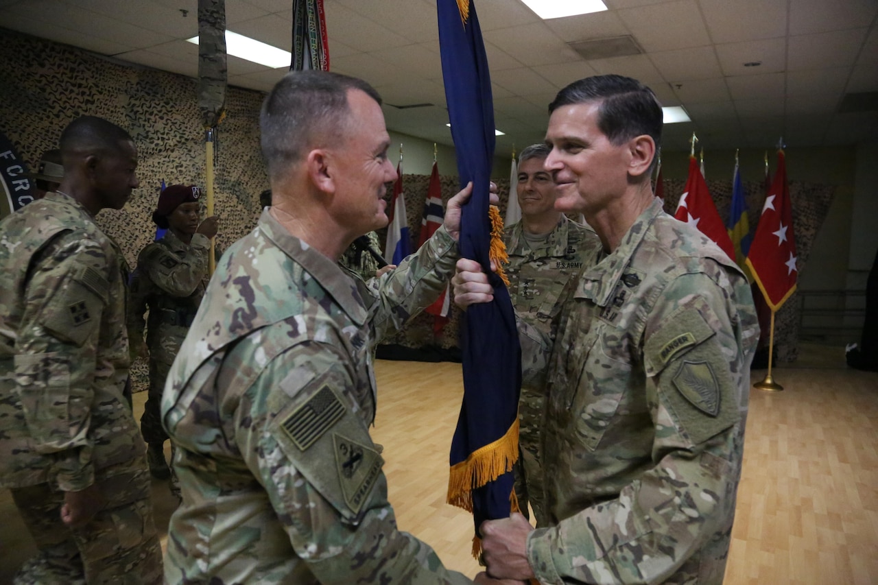 Army Lt. Gen. Paul Funk II, left, III Corps commander and the incoming commander of Combined Joint Task Force Operation Inherent Resolve, receives the CJTF-OIR colors