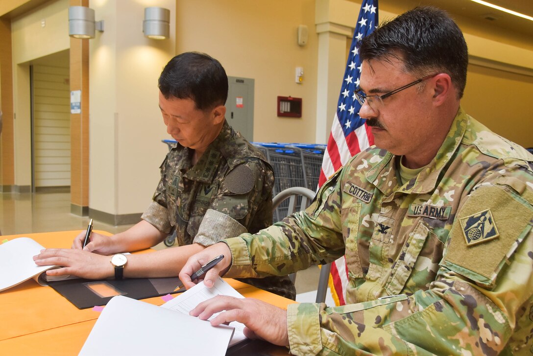 Col. Jeong Se-ok (left), Director General of Program Management, and Col. Garrett Cottrell, Deputy Military Chief United States Army Corps of Engineers Far East District, sign the United States Army Garrison Humphreys Armed Forces Exchange Acceptance Release Letter