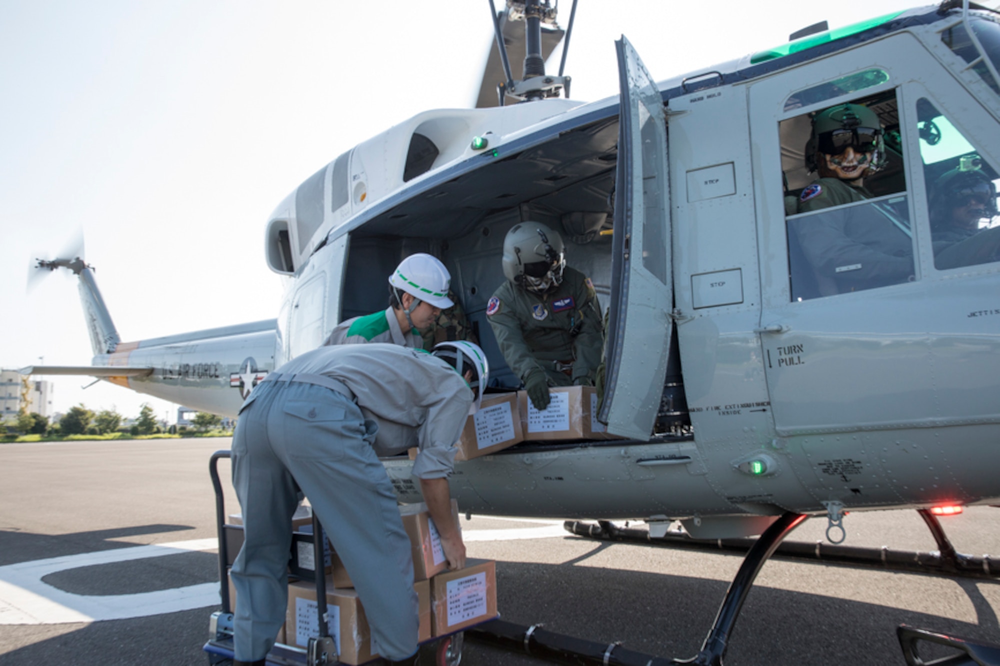 Members with the Tokyo Metropolitan Government load simulated relief supplies into a UH-1N Iroquois assigned to the 459th Airlift Squadron at Tokyo Rinkai Disaster Prevention Park, Koto Ward, Japan, Sept. 3, 2017