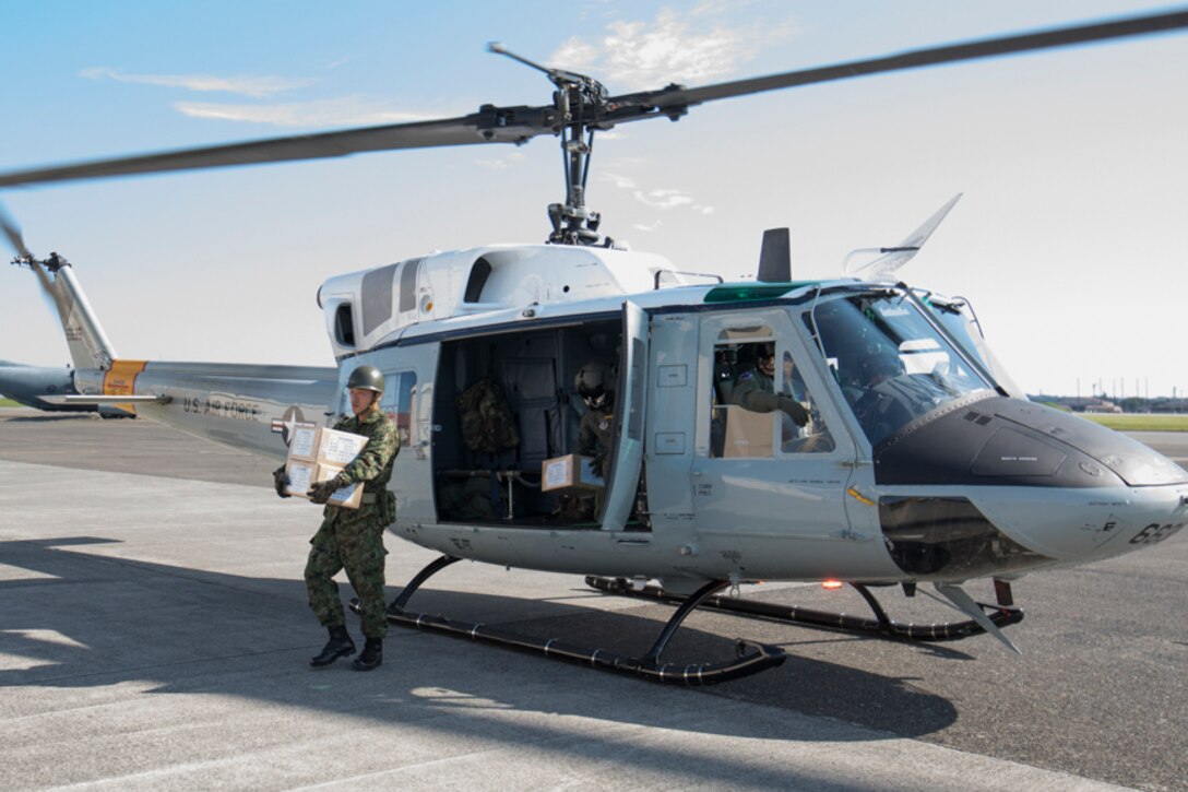 A Japan Ground Self-Defense Force member assigned to the 1st Logistics Regiment, JGSDF Nerima Station, carries simulated disaster relief supplies at Yokota Air Base, Japan
