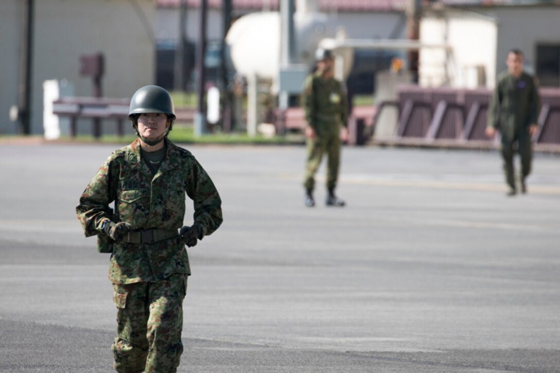 A Japan Ground Self-Defense Force solider assigned to the 1st Logistics Regiment, JGSDF Nerima Station, runs on the flight line at Yokota Air Base