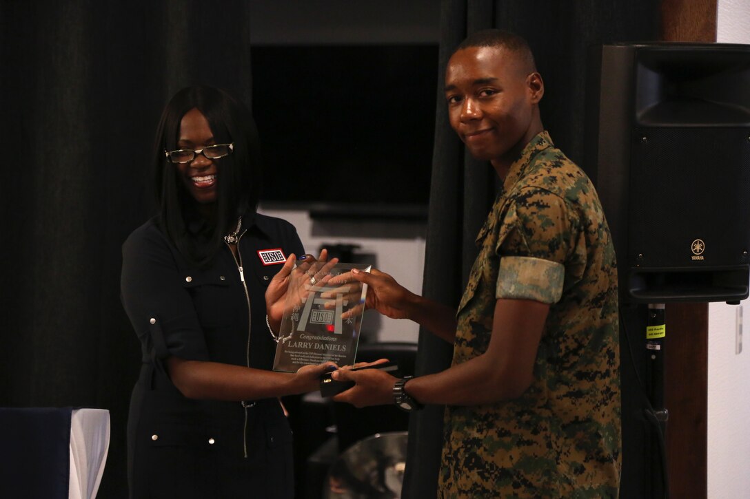 CAMP FOSTER, OKINAWA, Japan – Tamara Owens, left, presents Cpl. Larry Daniels the USO Okinawa Volunteer of the Quarter award Aug. 30 at the USO aboard Camp Foster, Okinawa, Japan.