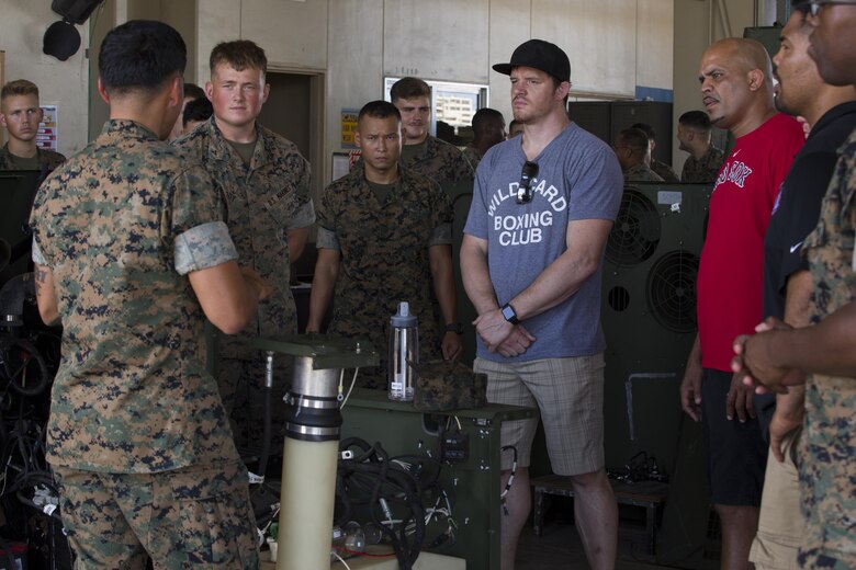 Staff Sgt.  Eric J. Martinez teaches mixed martial arts fighter  about Marine Corps equipment during a meet and greet