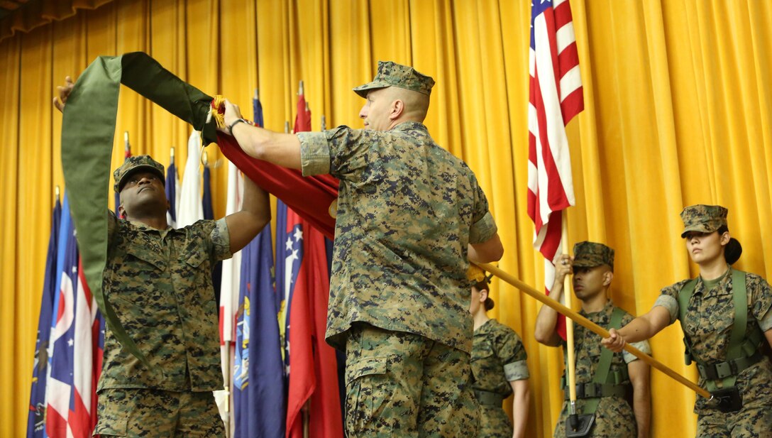 Col. Brian M. Howlett (left), commanding officer, III Marine Expeditionary Force Information Group, and Sgt. Maj. Mario P. Fields, sergeant major,  III MIG retire the III Marine Headquarters Group colors on Camp Courtney, Okinawa, Japan on Sept. 8, 2017. III MHG was re-designated in a ceremony as III MIG, highlighting the beginning of a new era of modern Marine Corps information warfare. (U.S. Marine Corps photo by Lance Cpl. Christian J. Lopez)