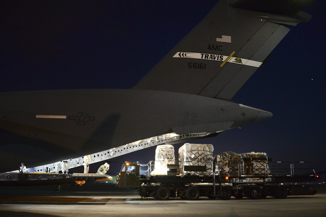 Airmen prepare to load four pallets of supplies onto a C-17 Globemaster III