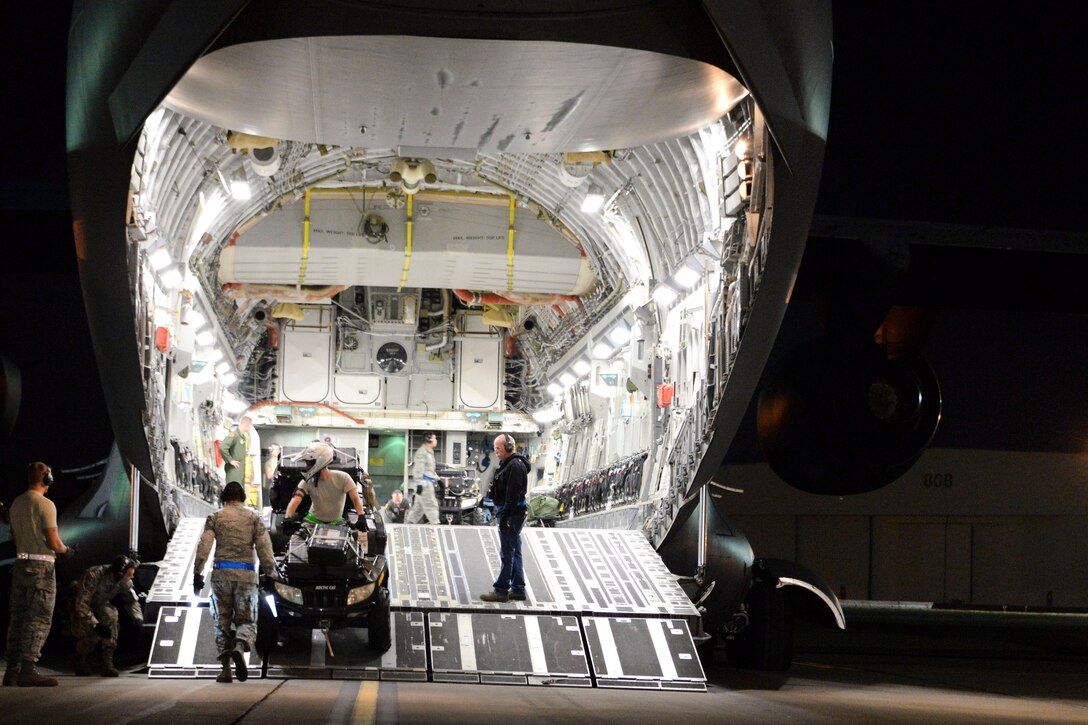 Airmen load an all-terrain vehicle onto a C-17 Globemaster III