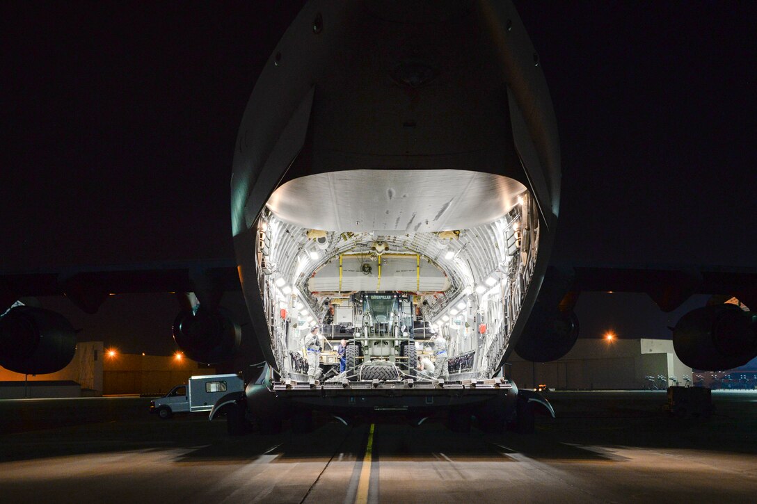 Airmen load vehicles, supplies and medical personnel onto a C-17 Globemaster III at Travis Air Force Base, Calif.