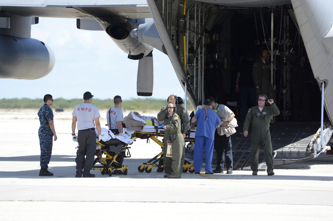 Military and civilian personnel load a patient onto a North Carolina Air National Guard C-130 Hercules at the Key West Naval Air Station, Fla.