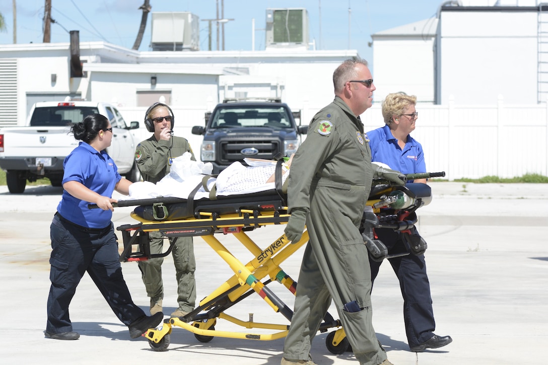 North Carolina Air National Guard Lt. Col. Charles Scronce, right, and Lt. Col. Lisa Reeves help transport a patient to a C-130 Hercules aircraft at Key West Naval Air Station, Fla.