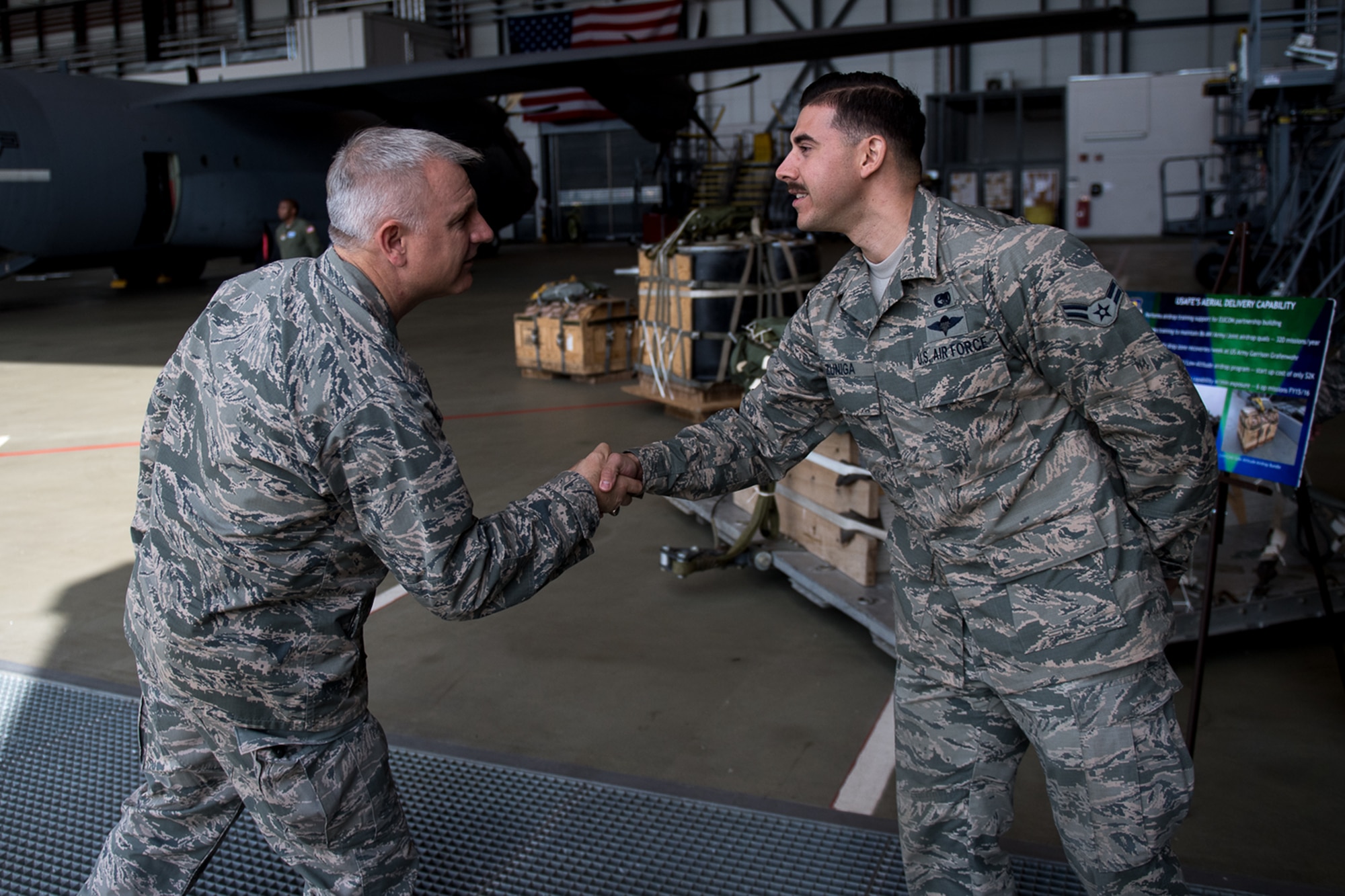 U.S. Air Force Maj. Gen. Timothy G. Fay, United States Air Forces in Europe and Air Forces Africa deputy commander, shakes hands with Airman 1st Class Peter Zuniga, 86th Logistics Readiness Squadron aerial delivery specialist, during an 86th Airlift Wing immersion tour in the dual bay on Ramstein Air Base, Germany, Sept. 7, 2017.