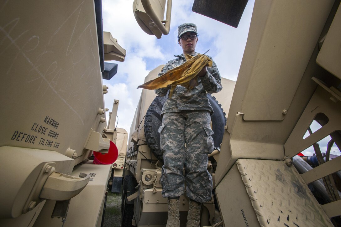 New Jersey Army National Guard Spc. Michelle Rivera checks the oil in a light medium tactical vehicle at Cape May Courthouse, N.J.