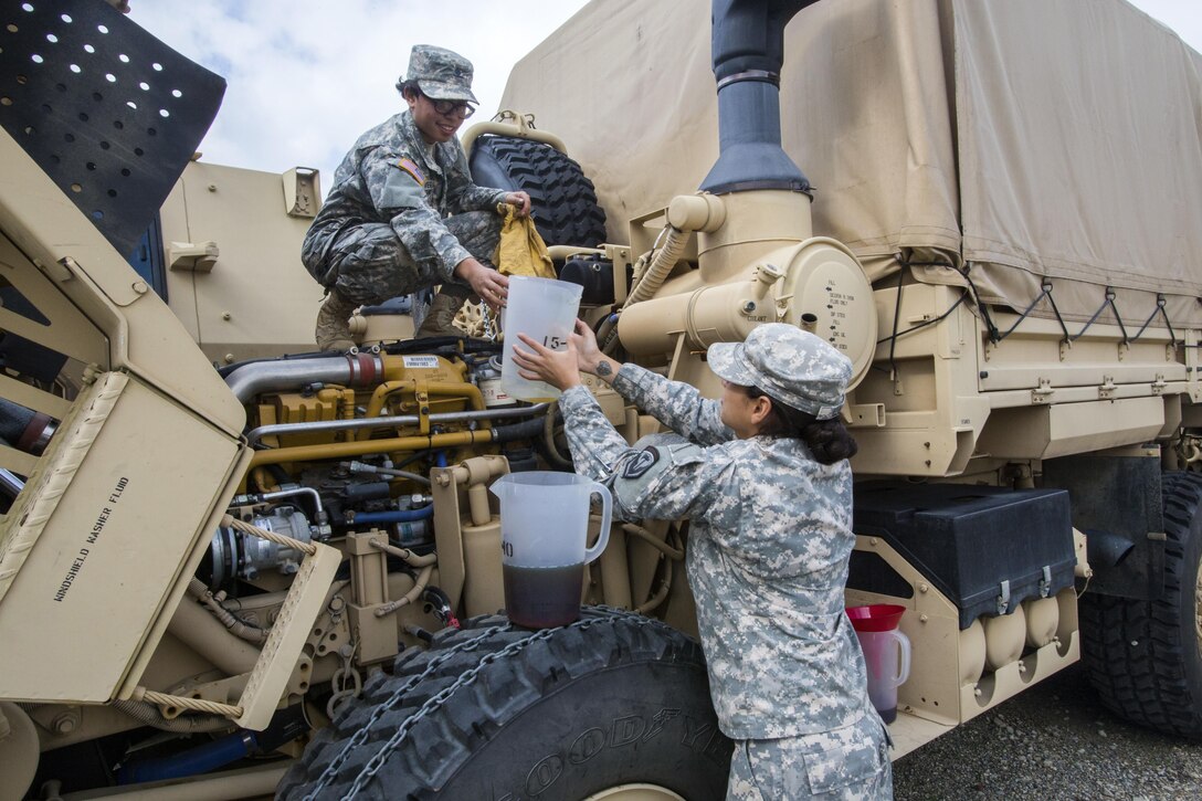 New Jersey Army National Guard Spcs. Michelle Rivera, left, and Jennifer Llufire prepare their vehicle at Cape May Courthouse, N.J., for a deployment.