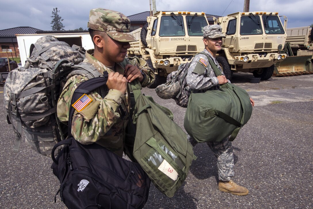 Soldiers assigned to the 253rd Transportation Company carry their gear out to a light medium tactical vehicle at Cape May Courthouse, N.J.