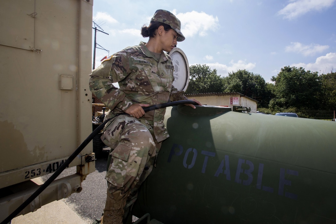 Army Pfc. Michaela Thomas fills a 400 gallon water trailer at Cape May Courthouse, N.J., as more than 130 New Jersey Army National Guardsmen prepare to deploy.
