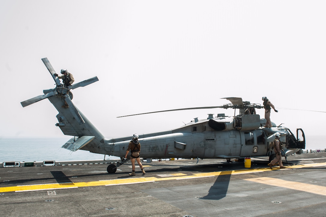 170907-N-AC254-392 U.S. 5TH FLEET AREA OF OPERATIONS (Sept. 7, 2017)
Sailors assigned to the “Wildcards” of Helicopter Sea Combat Squadron (HSC) 23 aboard the amphibious assault ship USS America (LHA 6) preflight checks on an MH-60S Sea Hawk helicopter during flight operations. Alligator Dagger is a dedicated, unilateral combat rehearsal led by Naval Amphibious Force, Task Force 51/5th Marine Expeditionary Brigade, in which combined Navy and Marine Corps units of the America Amphibious Ready Group and embarked 15th Marine Expeditionary Unit are to practice, rehearse and exercise integrated capabilities that are available to U.S. Central Command both afloat and ashore. (U.S. Navy photo by Mass Communication Specialist 2nd Class Alexander A. Ventura II/Released)