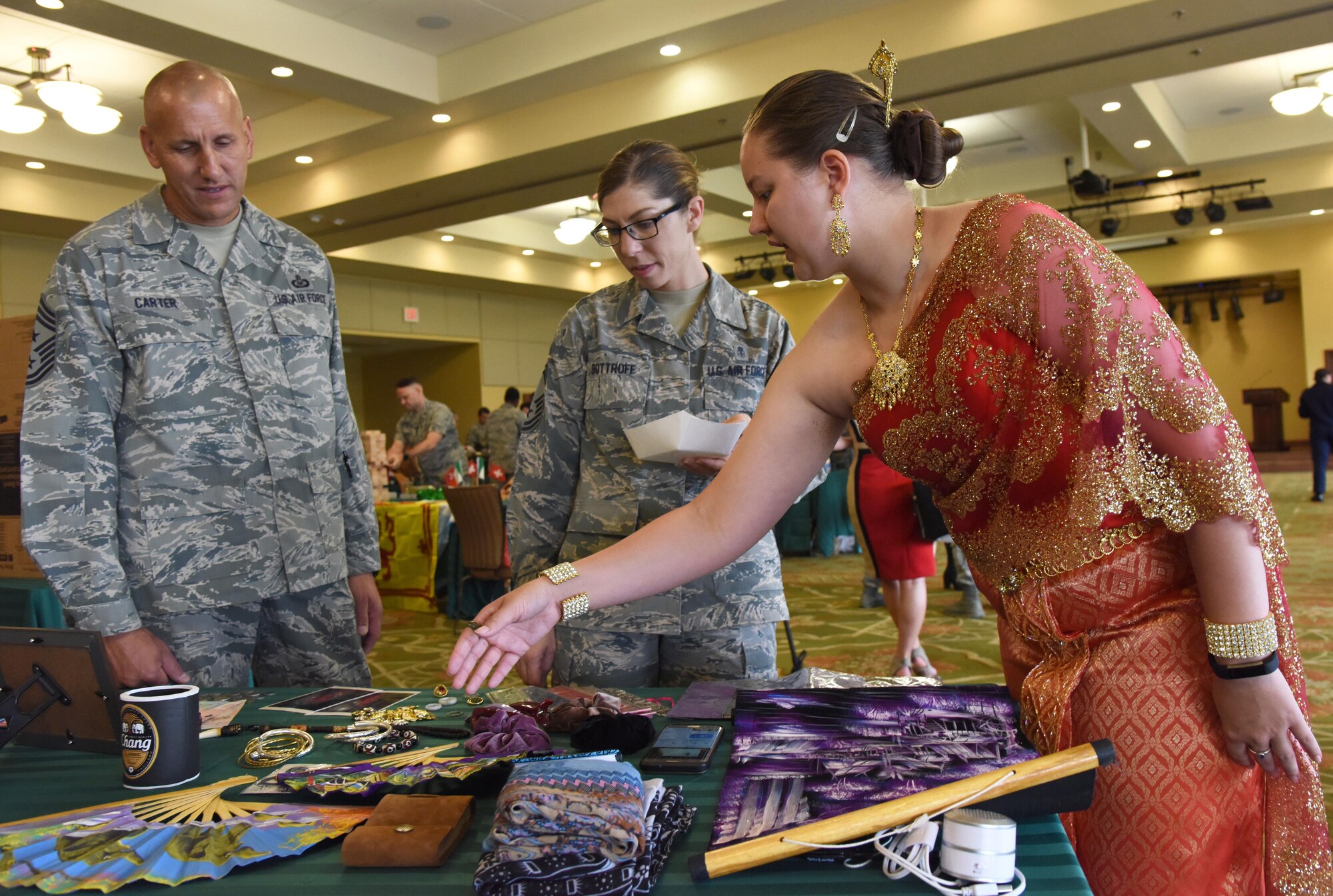 Senior Airman Savannah Slaughter, 81st Comptroller Squadron budget analyst, showcases Thailand memorabilia to Chief Master Sgts. Kenneth Carter, 81st Training Wing command chief, and Julie Bottroff, 81st Medical Group superintendent, during Diversity Day at the Bay Breeze Event Center Sept. 6, 2017, on Keesler Air Force Base, Miss. The cultural celebration included food sampling and information booths about countries around the world and other special emphasis groups. (U.S. Air Force photo by Kemberly Groue)