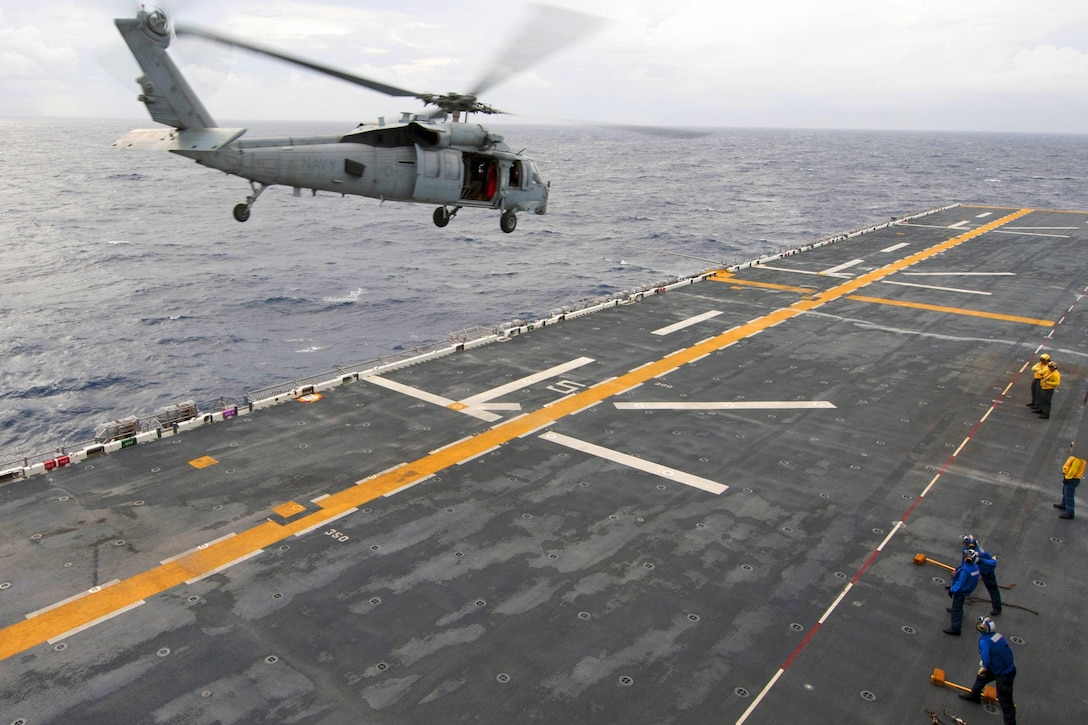 A helicopter takes off from the runway on a ship.