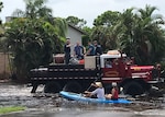 San Carlos Park Fire Fighters use a former military cargo truck to navigate flooded streets from heavy rains to rescue 210 people and 50 animals.