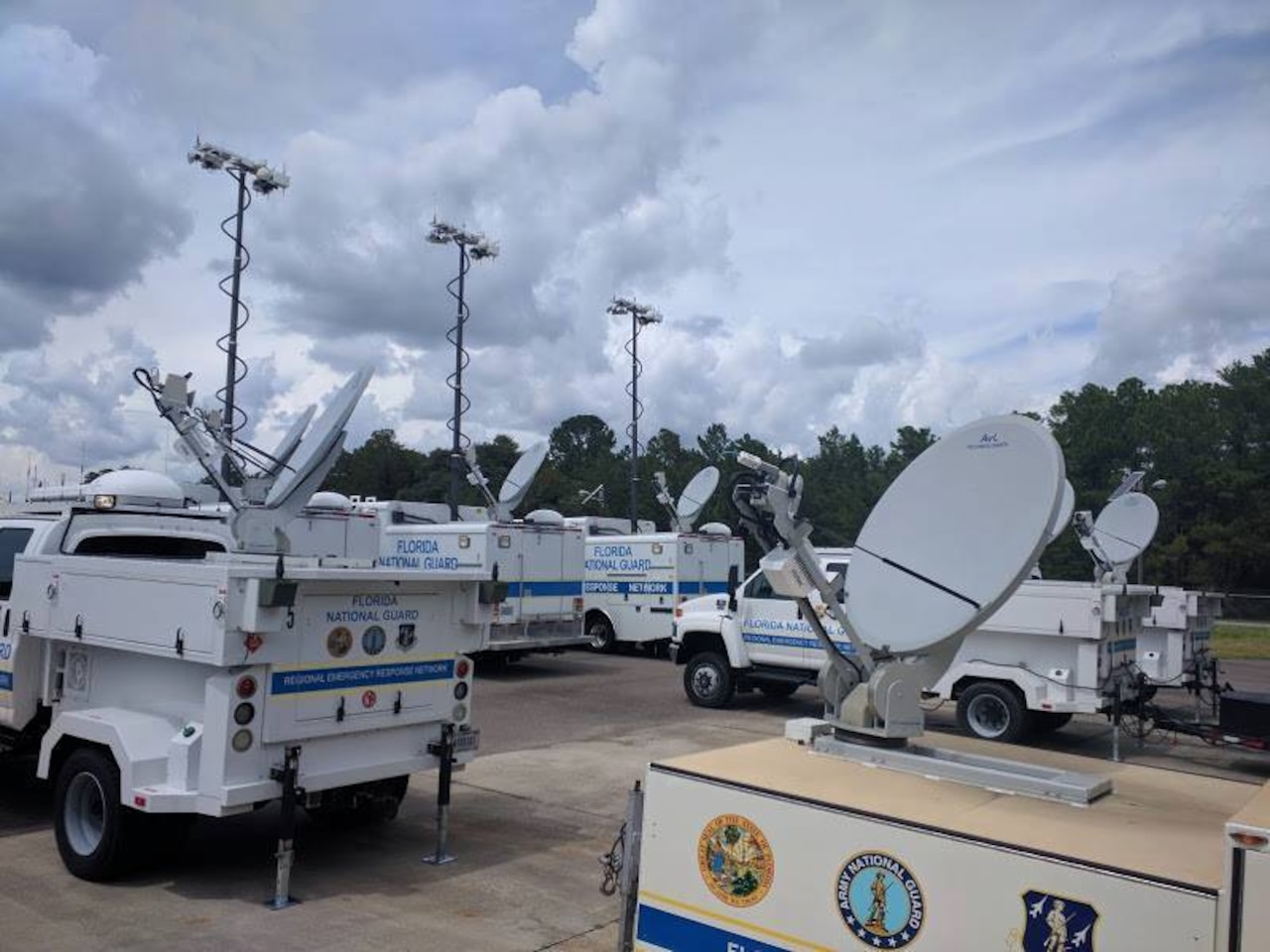 Florida National Guard satellite communications vehicles are gathered at a staging area