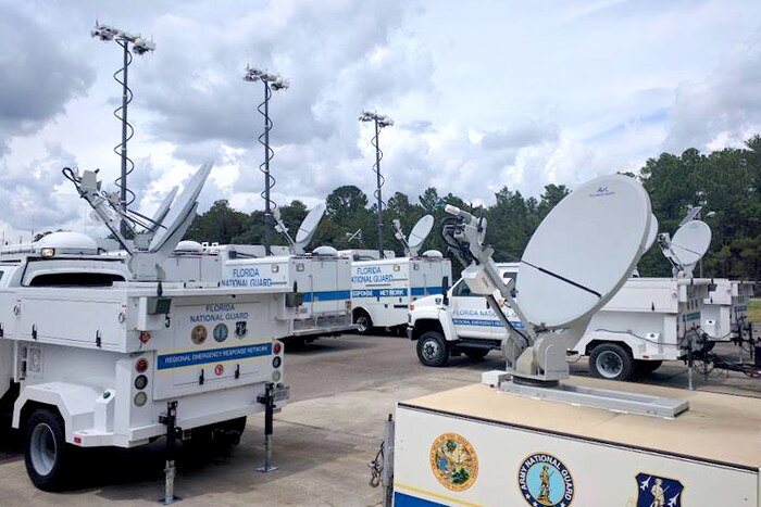 Florida National Guard satellite communications vehicles are gathered at a staging area