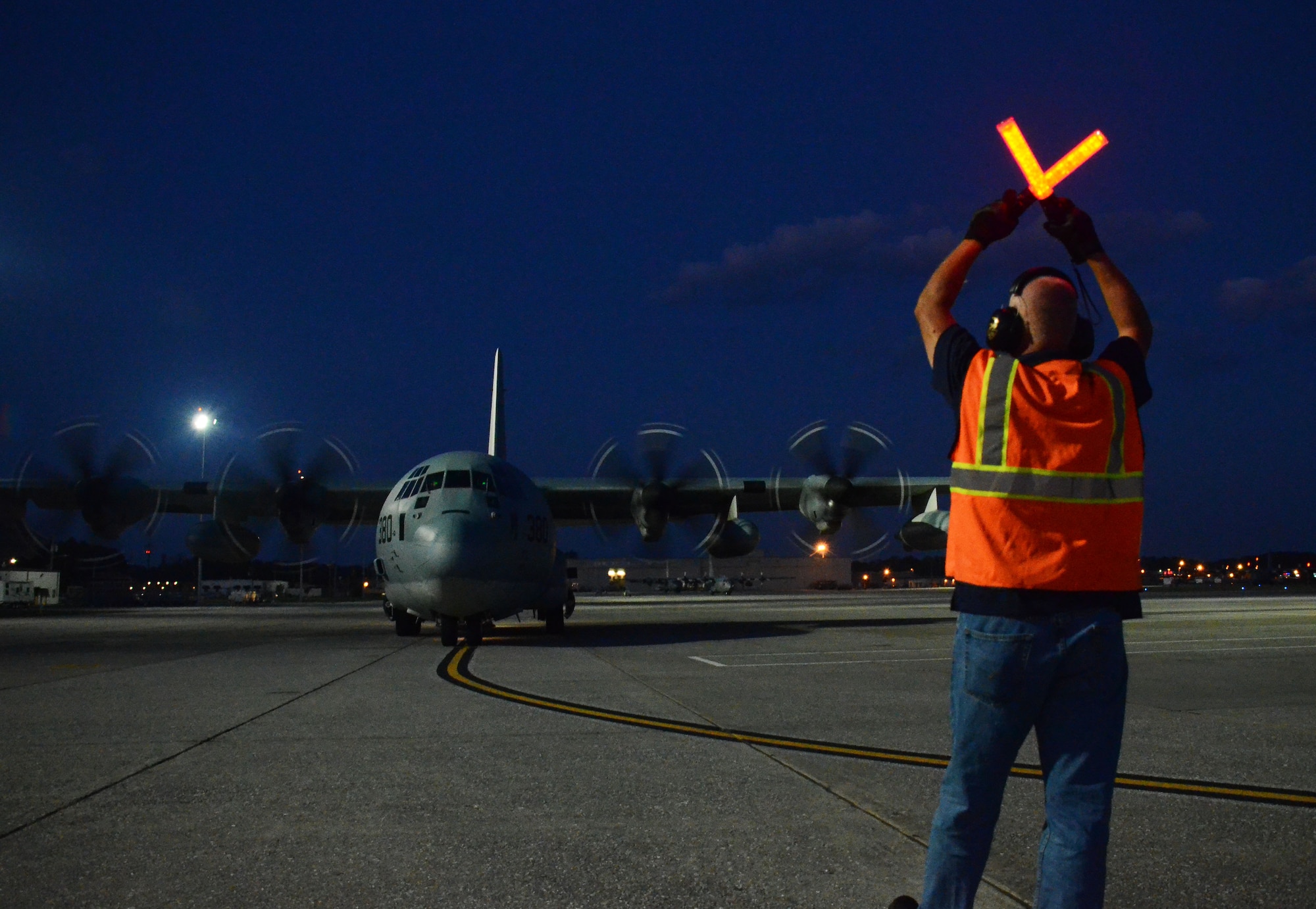 A Dobbins airfield manager guides in a C-130 as it taxis on the flightline at Dobbins Air Reserve Base, Ga. Sept. 6, 2017. The aircraft carried civilian and contract Department of Defense personnel who were evacuated from the Caribbean. (U.S. Air Force photo/Don Peek)