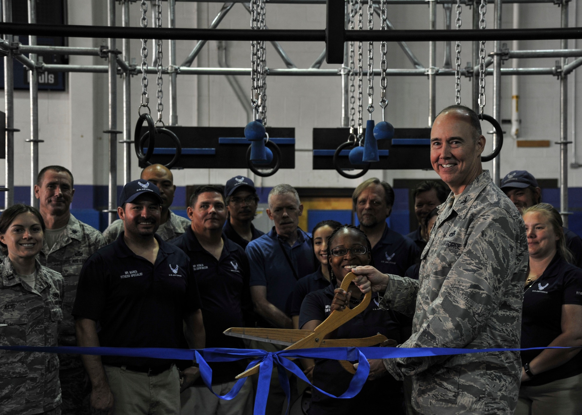 Col. Richard W. Gibbs, 377th Air Base Wing commander, joins with gym employees for the ribbon-cutting ceremony at the East Side Fitness Center on Kirtland Air Force Base, New Mexico Aug. 30. Several Kirtland Air Force Base leaders gathered to celebrate the gym’s recent renovations. (U.S. Air Force Photo/Airman First Class Alexandria Crawford)