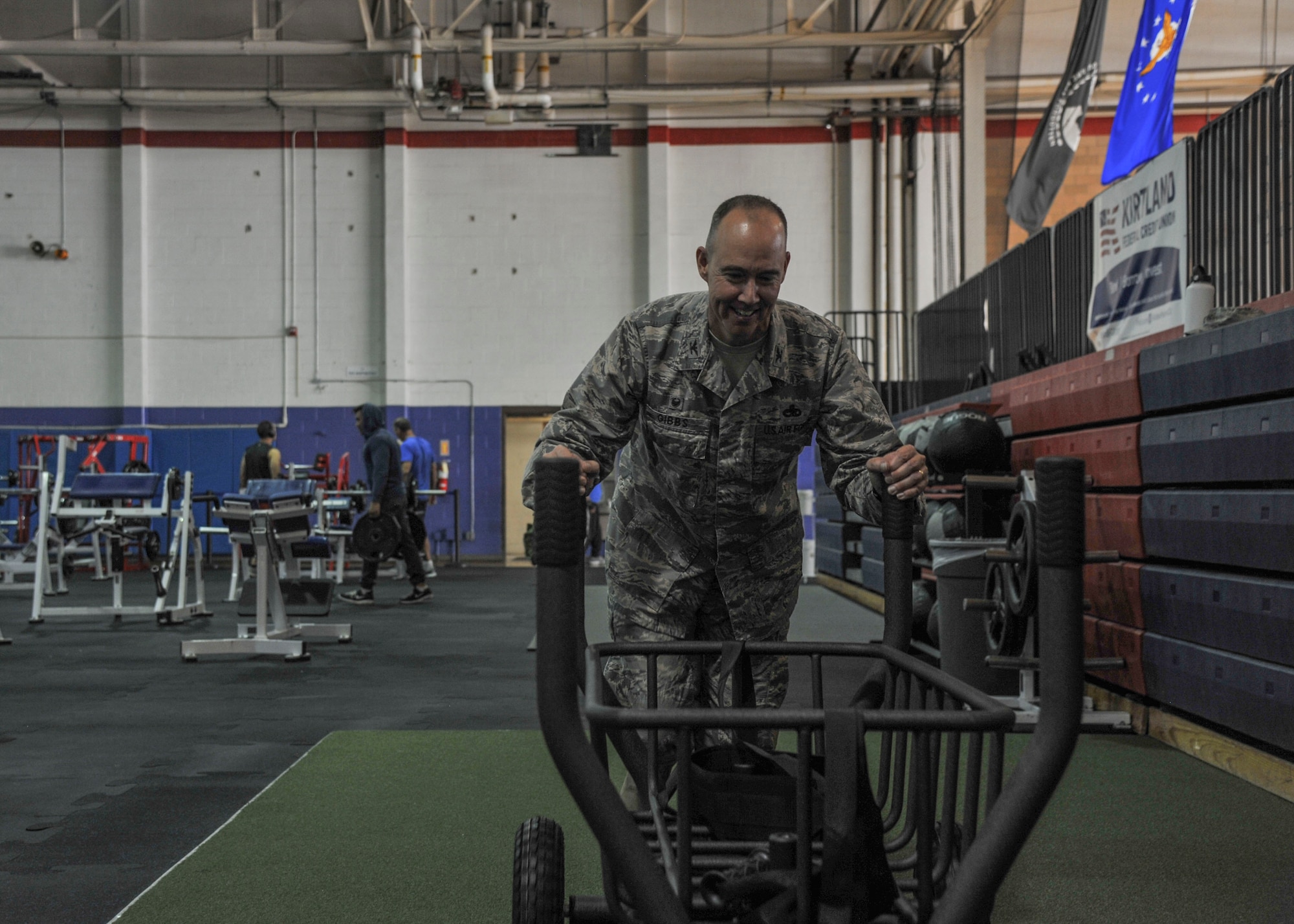Colonel Richard W. Gibbs, 377th Air Base Wing commander, tries out some of the new workout equipment after the ceremony at the East Side Fitness Center on Kirtland Air Force Base, New Mexico Aug. 30. The new devices are not only easy to use for Airmen who are looking to take their training to the next level, they’re also meant to be a little bit of fun as well. (U.S. Air Force Photo/Airman First Class Alexandria Crawford)