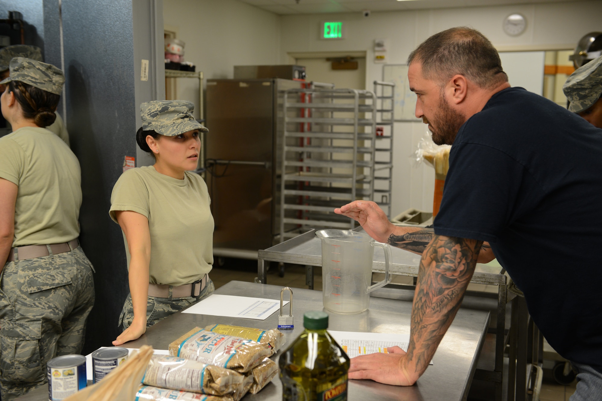 Chef Darryl Moiles explains meal preparation instructions to Senior Airman Secilia Peraza, 90th Force Support Squadron missile field chef, Sept. 6, 2017, at Malmstrom Air Force Base, Mont. Missile field chefs from Malmstrom, Minot AFB, N.D, and F.E. Warren AFB, Wyo., prepared food for the base under the guidance and mentoring from Chefs Robert Irvine and Moiles. (U.S. Air Force photo/Staff Sgt. Delia Martinez)