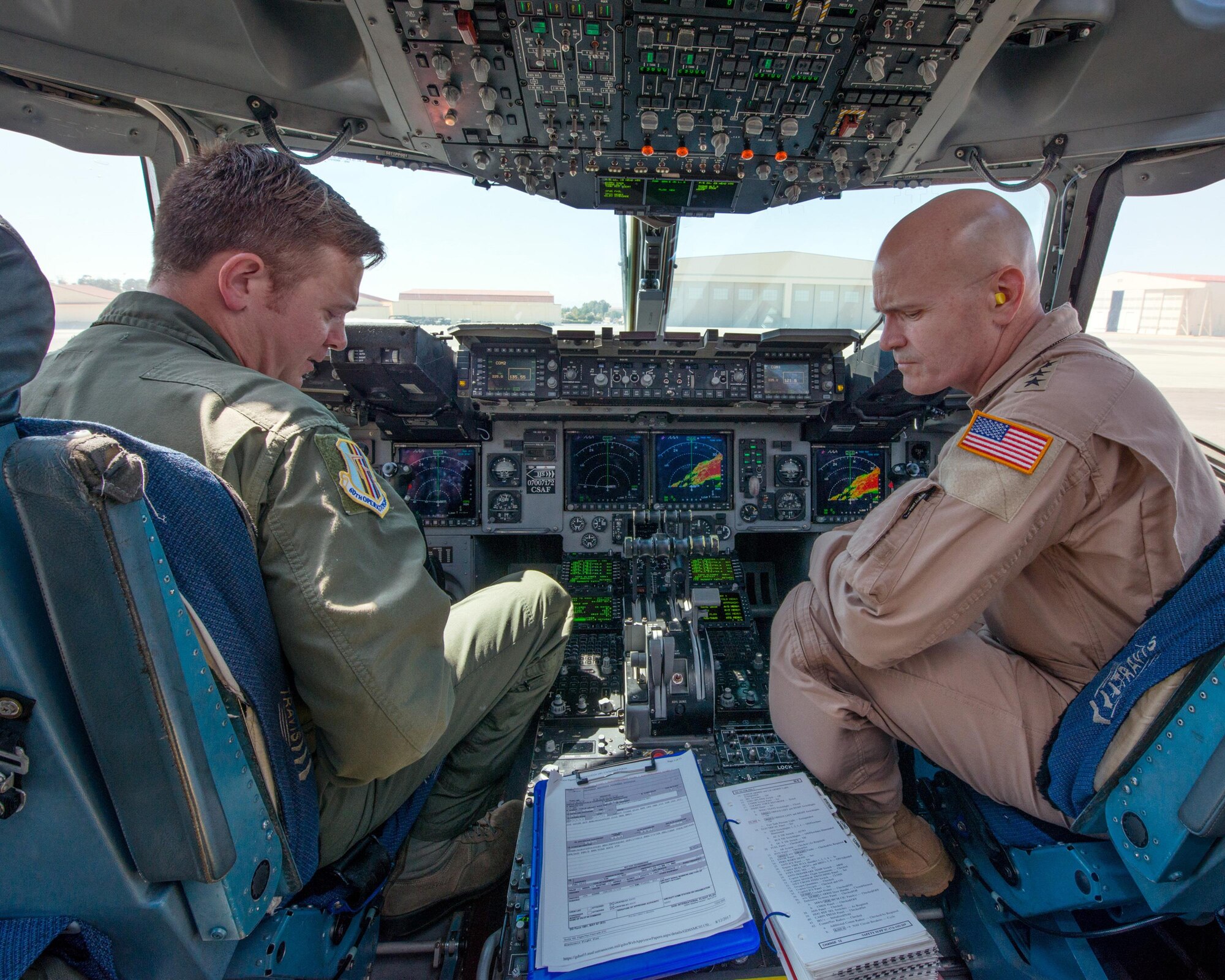 U.S. Air Force Gen. Carlton D. Everhart II, Air Mobility Command commander, Scott Air Force Base, Ill., talks with Tech. Sgt. Nathaniel Harris, 60th Operations Group, about a newly developed mounted electronic flight bag holder for the C-17 Globemaster III at Travis Air Force Base, Calif., August 12, 2017. Under the auspice of Phoenix Spark, the 60th OG is working with the 60th Maintenance Group to design and approve the mount for all three aircraft assigned to the 60th Air Mobility Wing. This was the first time any USAF aircrew had utilized the new EFB mount. Phoenix Spark is a program chartered by Everhart to empower AMC Airmen to innovate in finding ways to modernize the Air Force. (U.S. Air Force photo by Louis Briscese)