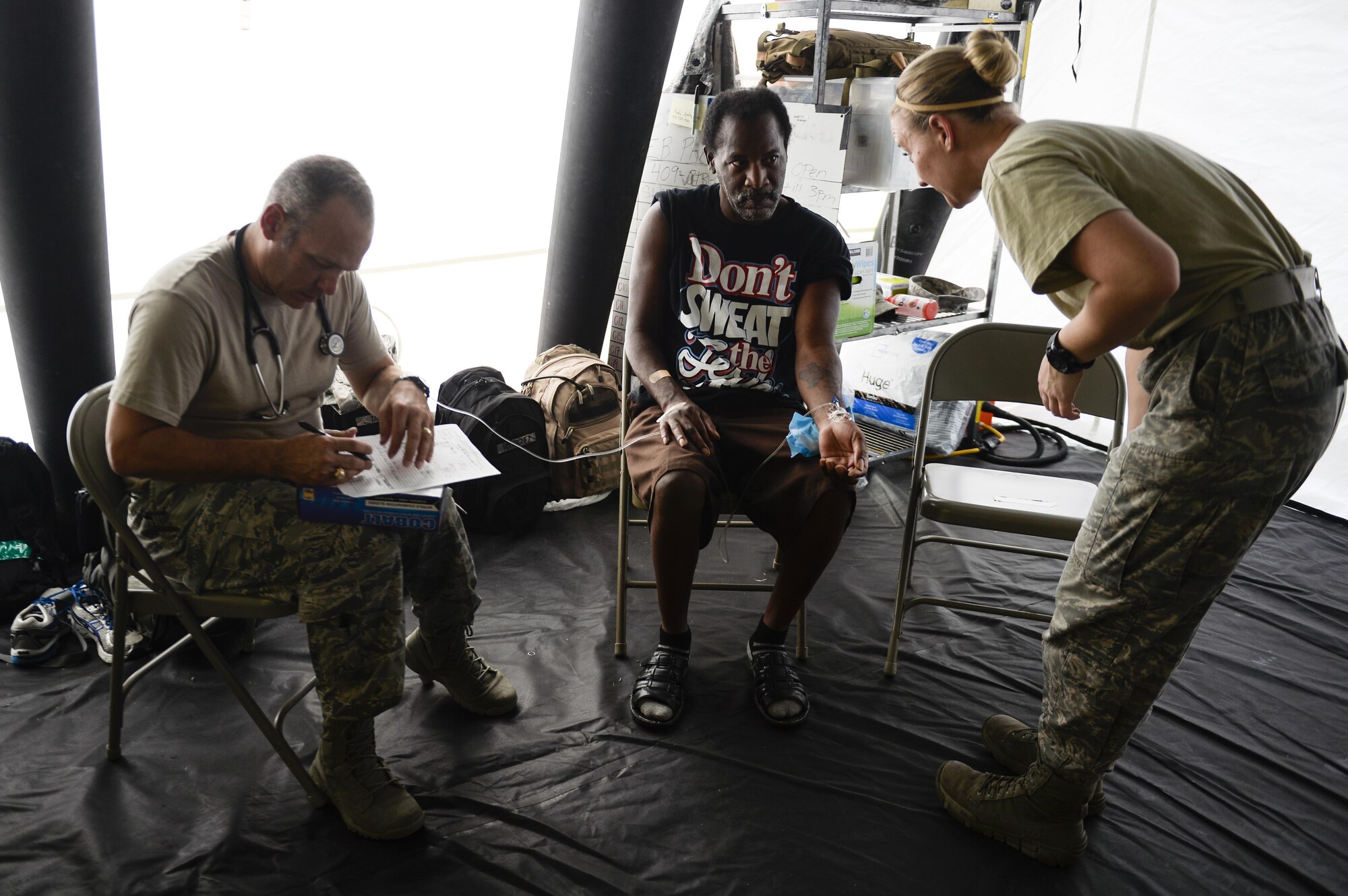 A patient receives care at a field hospital from Capt. Jerrod Taber, a physician's assistant, and Senior Airman Micah Battistoni, a medical technician, with the 149th Medical Group, Joint Base San Antonio, Texas, Sept. 3, 2017. The field hospital set-up in the parking lot of the Baptist Hospitals  of Southeast Texas as the hospital was only taking medical emergencies due to damage caused by Hurricane Harvey. (U.S. Air Force photo by Master Sgt. Joshua L. DeMotts)