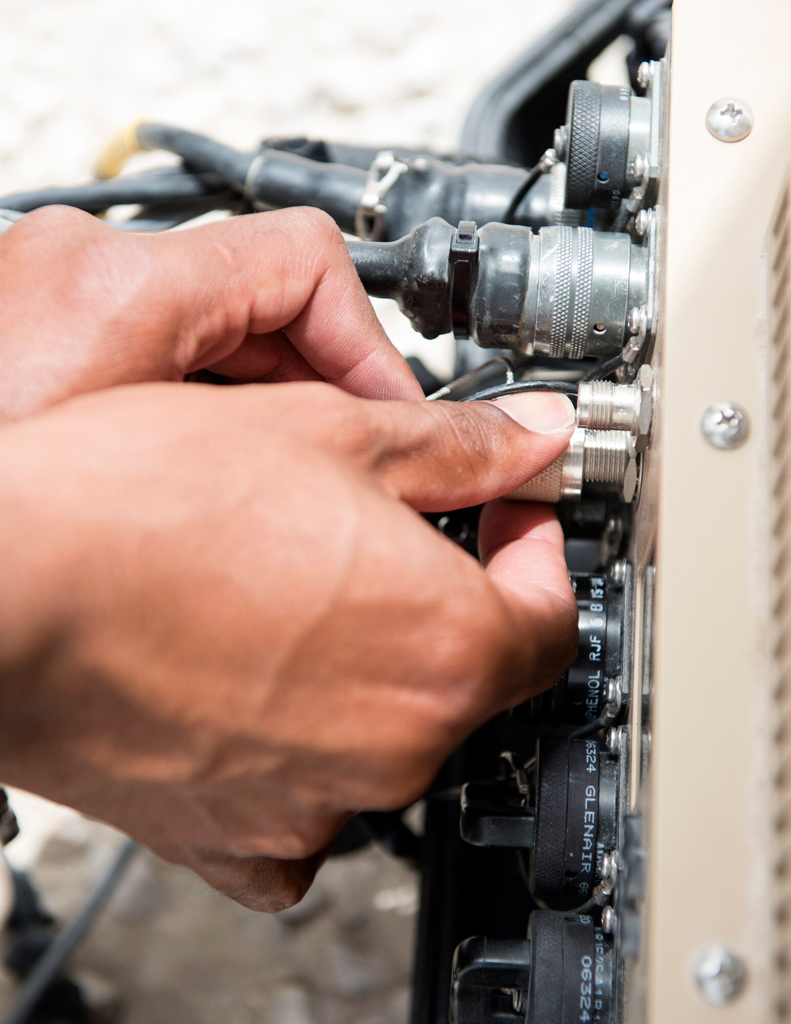 U.S. Air Force Staff Sgt. Ali Shekhey, a radio frequency transmission specialist with the 379th Expeditionary Communication Squadron, plugs in cables on a Hawkeye satellite at Al Udeid Air Base, Qatar, July 14, 2017.