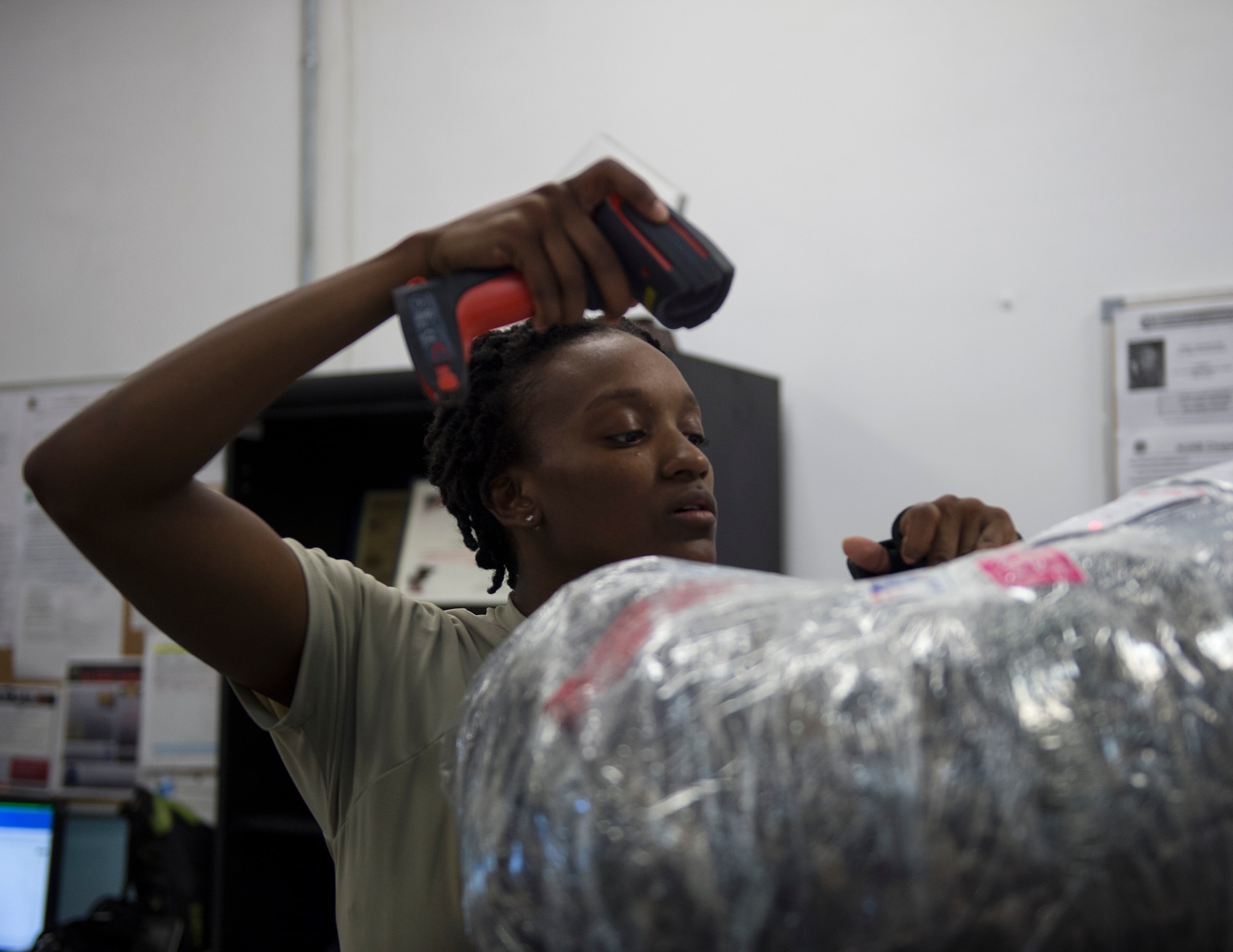 U.S. Air Force Senior Airman Daphney Wyatt, a military postal clerk with the 379th Expeditionary Communication Squadron scans outgoing mail in the system at Al Udeid Air Base, Qatar, July 14, 2017.