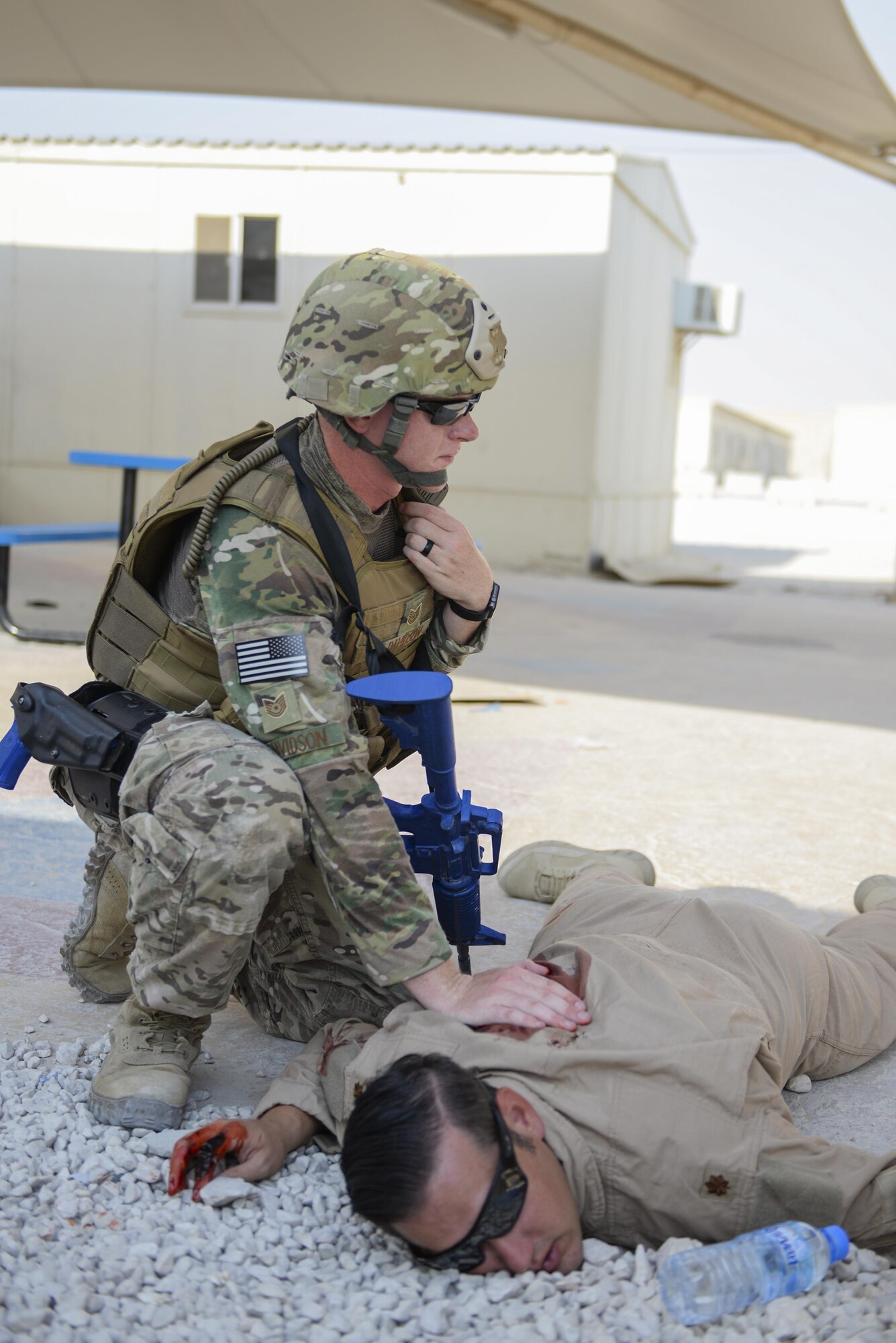 U.S. Air Force Tech. Sgt. Timothy Davidson, patrolman assigned to the 379th Expeditionary Security Forces Squadron, applies pressure to a wound on the back of simulated casualty, Master Sgt. Preston Davis, leased vehicle fleet manager assigned to the 379th Expeditionary Logistics Readiness Squadron, as they take part in an active shooter exercise conducted at Al Udeid Air Base, Qatar, Aug. 31, 2017.