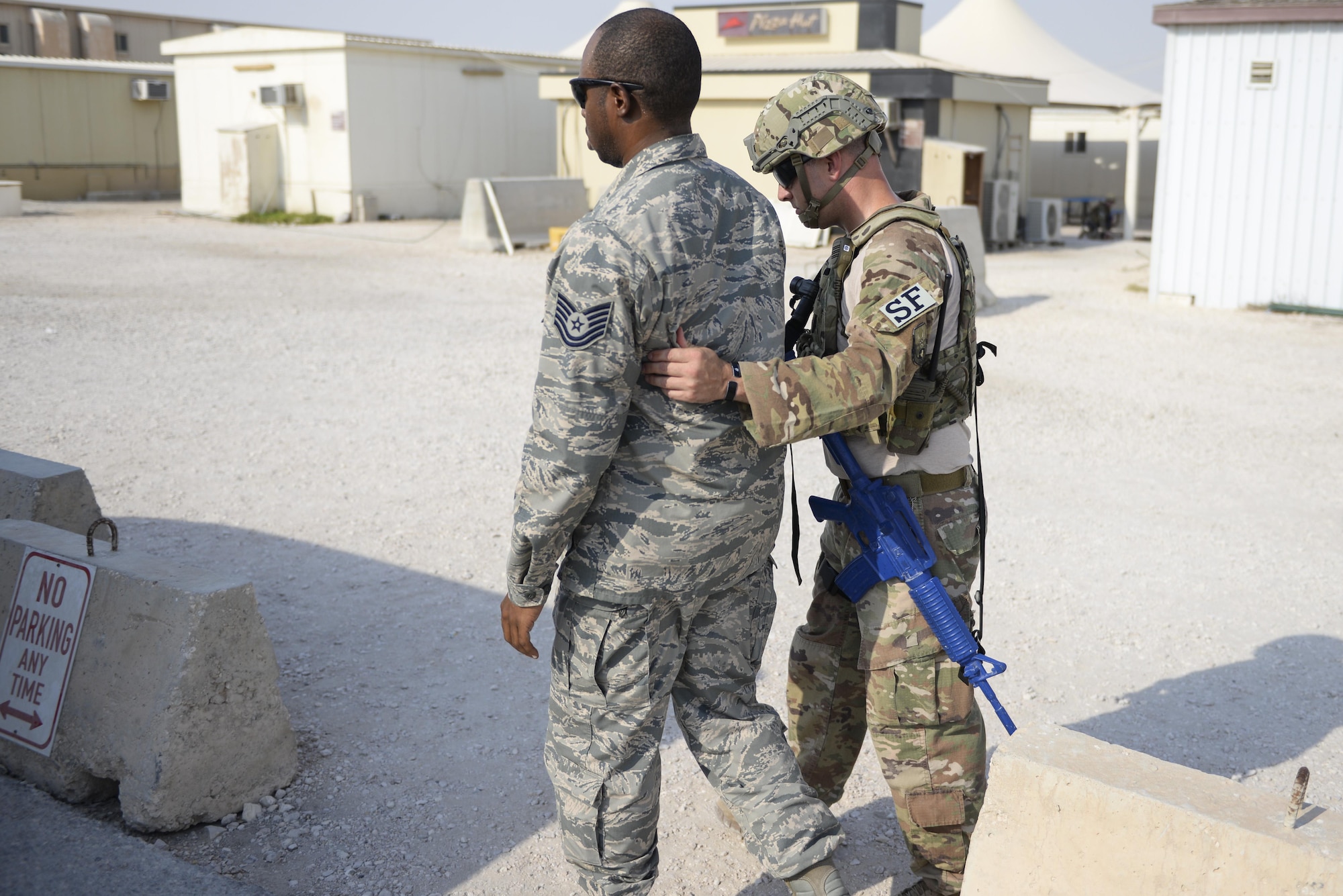 U.S. Air Force Tech. Sgt. Seth Oszust, patrolman assigned to the 379th Expeditionary Security Forces Squadron, directs simulated casualty, Tech. Sgt. Courtney Bonner, non-commissioned officer in charge assigned to the 379th Expeditionary Logistics Readiness Squadron, to safety as they take part in an active shooter exercise conducted at Al Udeid Air Base, Qatar, Aug. 31, 2017.