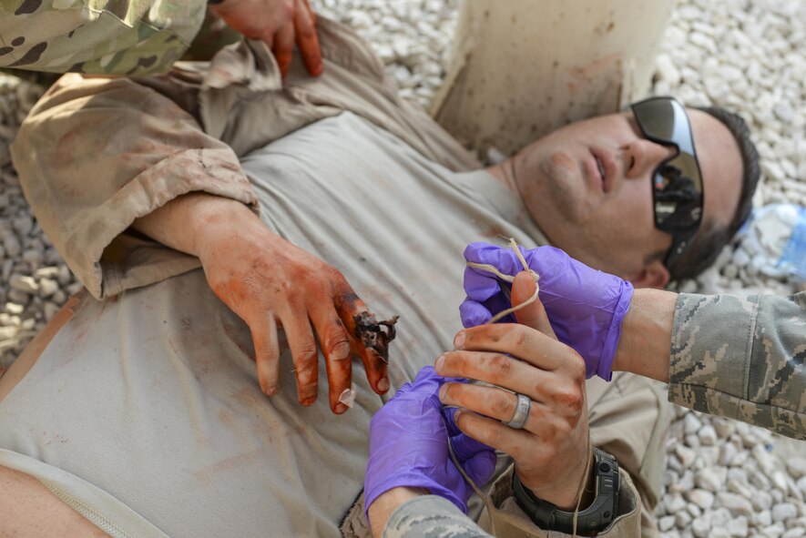 U.S. Air Force Master Sgt. Preston Davis, leased vehicle fleet manager assigned to the 379th Expeditionary Logistics Readiness Squadron, plays the part of a simulated casualty during an active shooter exercise conducted at Al Udeid Air Base, Qatar, Aug. 31, 2017.