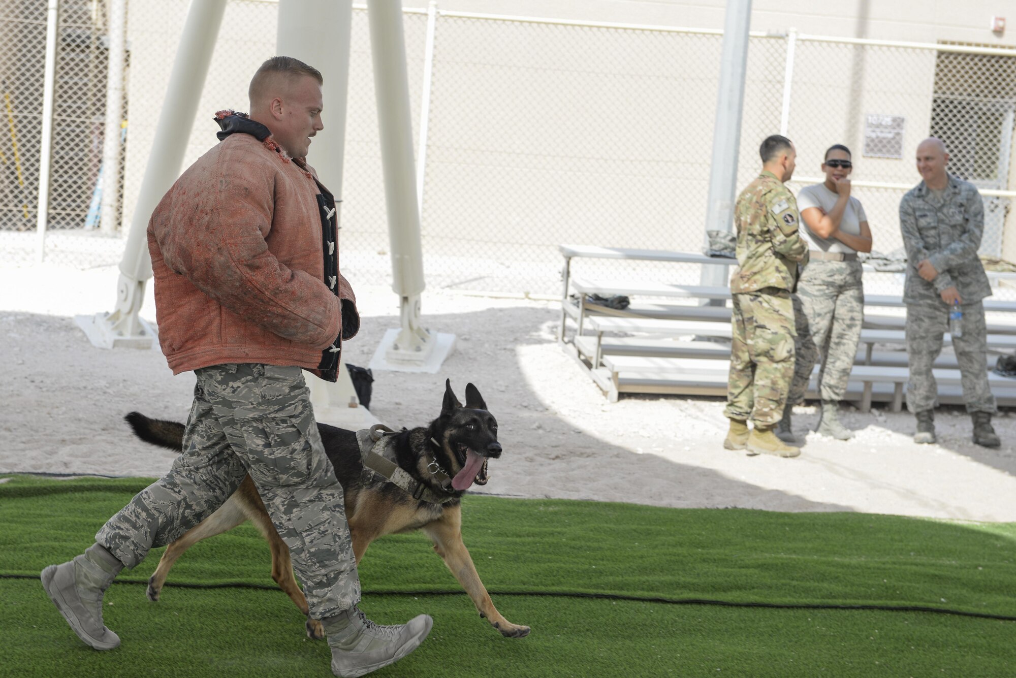 U.S. Air Force Senior Airman Louis Hurbis, military working dog handler assigned to the 379th Expeditionary Security Forces Squadron, is “escorted” after being detained by military working dog, Hugo, during a K-9 demonstration exercise at Al Udeid Air Base, Qatar, Aug. 17, 2017.