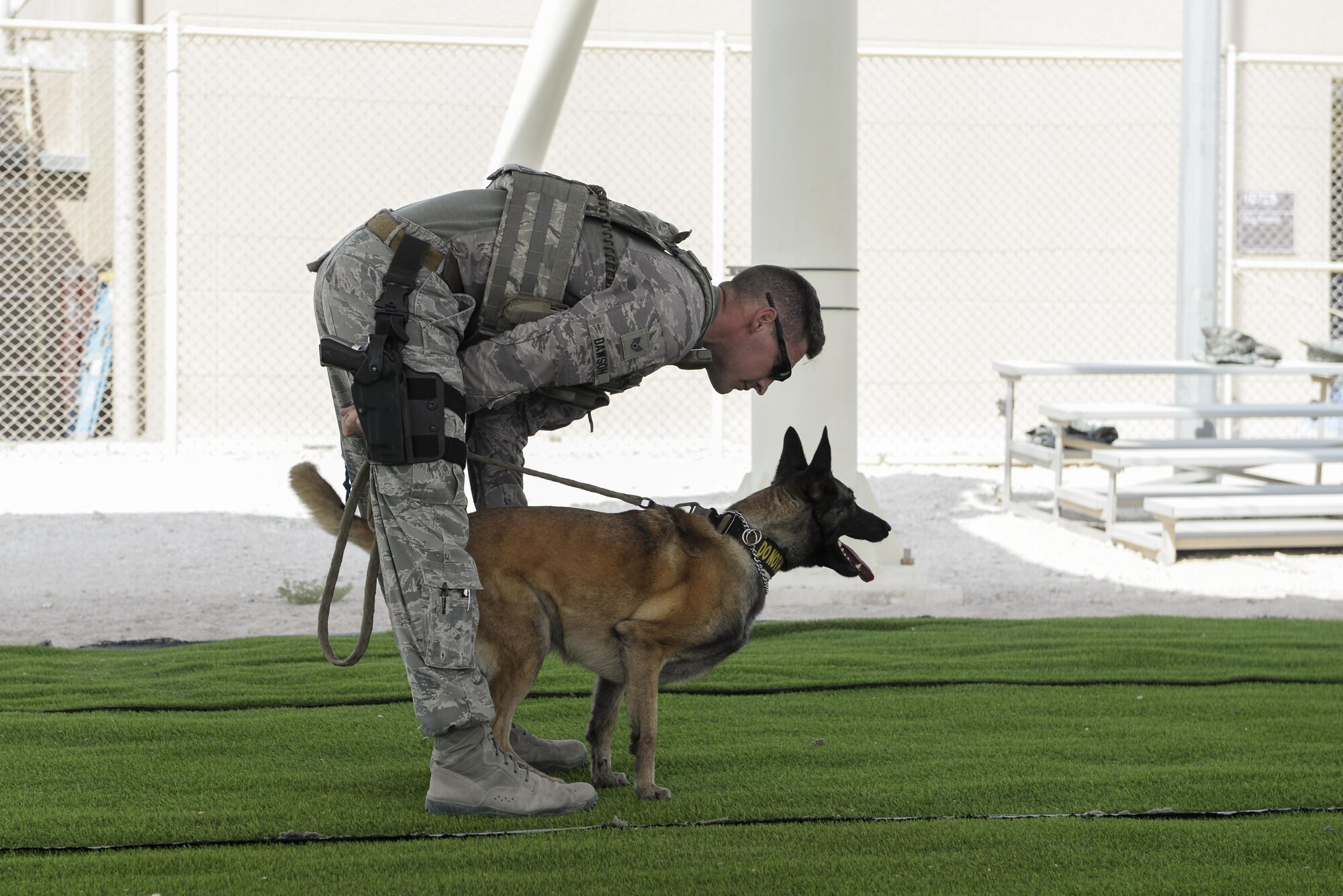 U.S. Air Force Staff Sgt. Timothy Dawson, military working dog handler assigned to the 379th Expeditionary Security Forces Squadron, prepares to release his military working dog,Mmaura, on a “suspect” during a K-9 demonstration exercise at Al Udeid Air Base, Qatar, Aug. 17, 2017