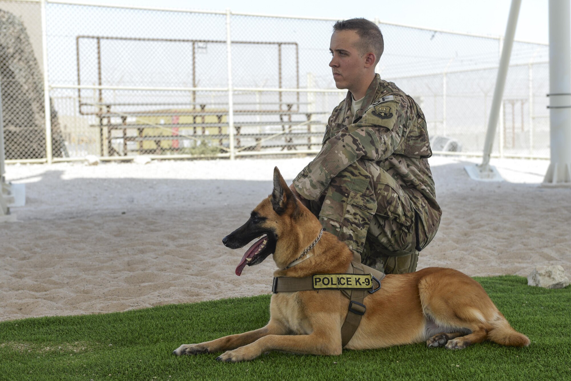 U.S. Air Force Senior Airman Brandon O’Toole, military working dog handler assigned to the 379th Expeditionary Security Forces Squadron, and his military working dog Oopey, wait for their turn to participate in a K-9 demonstration exercise at Al Udeid Air Base, Qatar, Aug. 17, 2017.