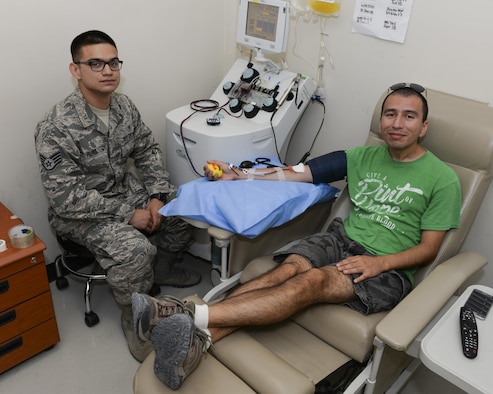 U.S. Air Force Senior Airman, Matthew Echeverria, collection planner assigned to the 609th Air Operations Center, donates blood platelets while Staff Sgt. Jose Perez, non-commissioned officer of testing assigned to the 379th Expeditionary Apheresis Element, monitors the donation process at Al Udeid, Air Base, Qatar, Aug. 23, 2017.