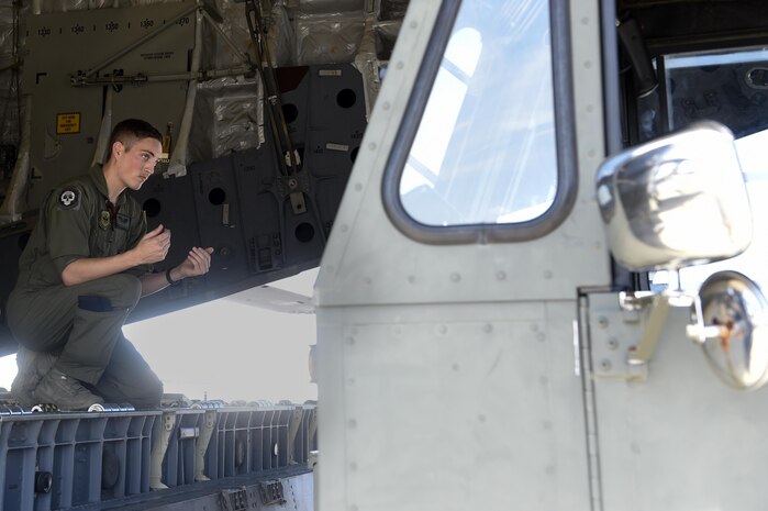 Staff Sgt. Dungan Farver, 16th Airlift Squadron loadmaster, directs a k-loader as it backs up to a C-17 Globemaster III Sept. 8, 2017.