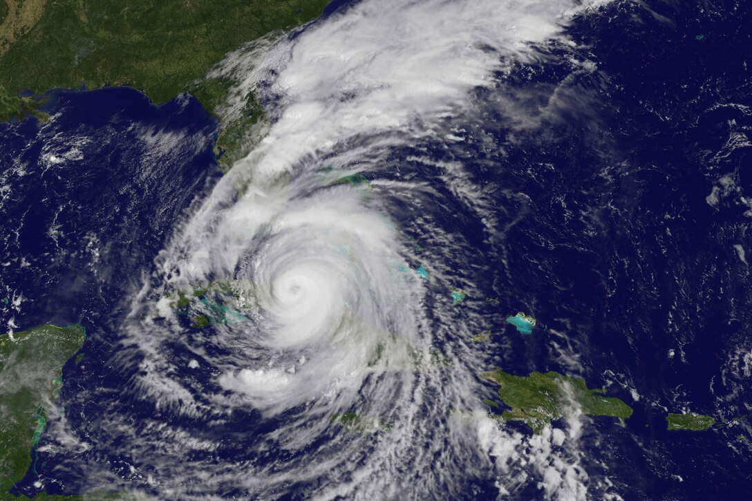 Satellite imagery shows a massive circular white storm cloud south of Florida.